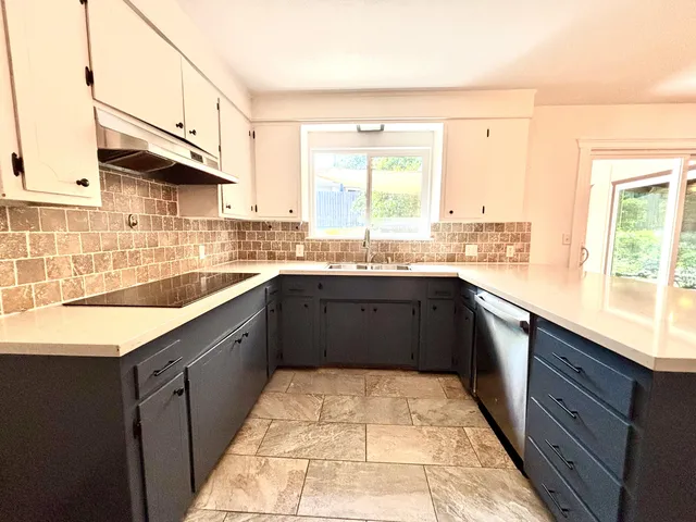 a kitchen with stainless steel appliances granite countertop a sink stove and cabinets