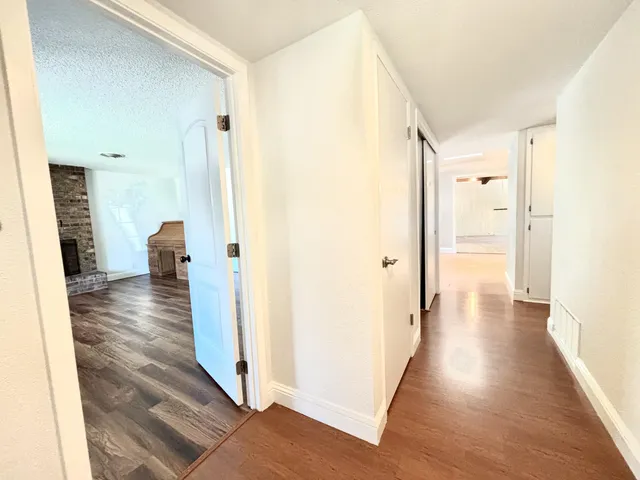 a view of a hallway with wooden floor and closet