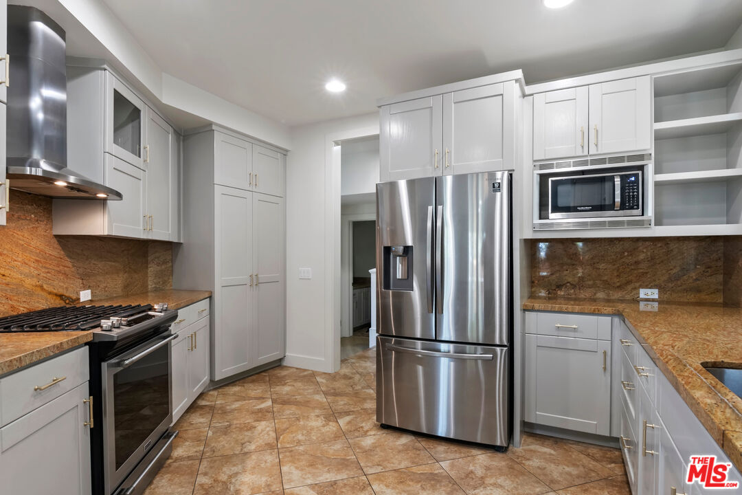 23550 Valley View Road Calabasas, CA 91302 - Photo 5 of 24 a kitchen with stainless steel appliances granite countertop a refrigerator stove and microwave