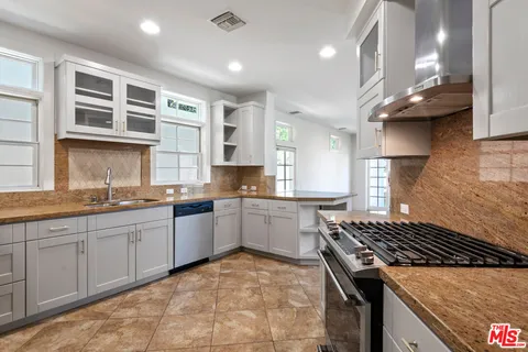 a kitchen with stainless steel appliances granite countertop a stove a sink and a microwave