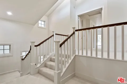 a view of staircase with railing and white walls
