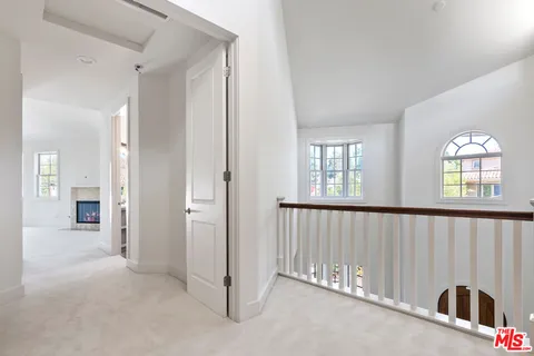 an empty room with windows and a fireplace