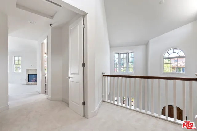 an empty room with windows and a fireplace