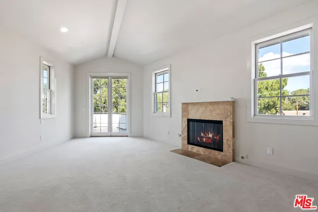an empty room with a fireplace and window
