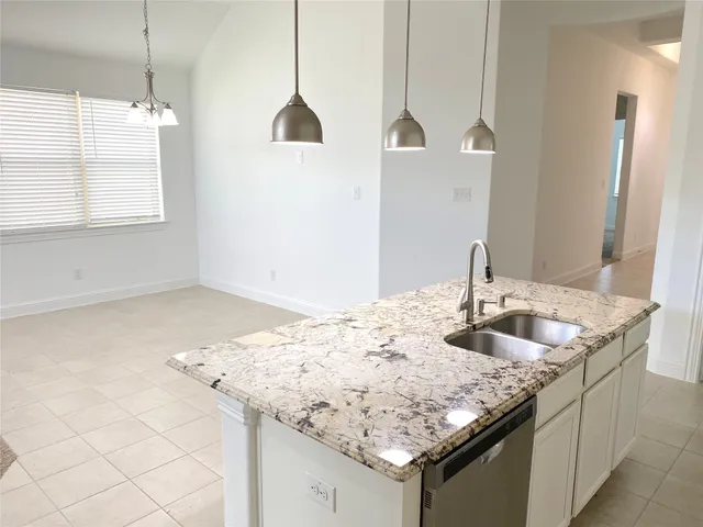 a kitchen with granite countertop a sink and a wooden floor