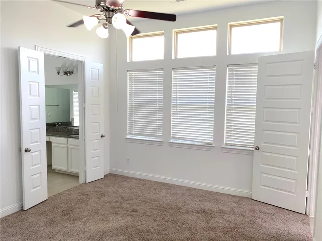 a view of an empty room with a window and a kitchen