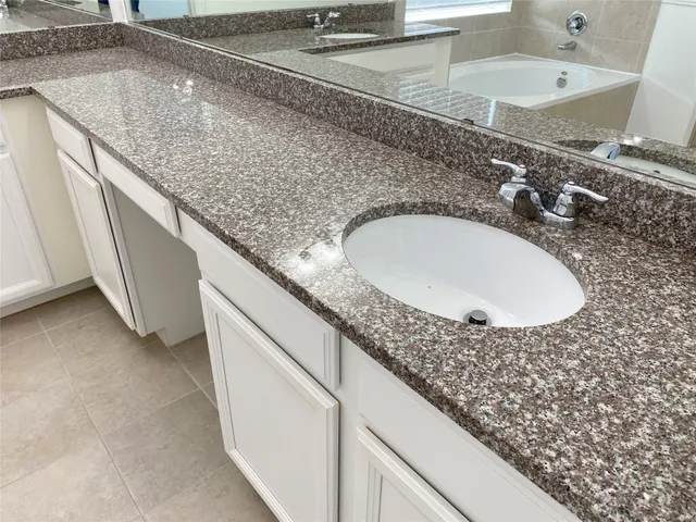 a bathroom with a granite countertop sink and a mirror