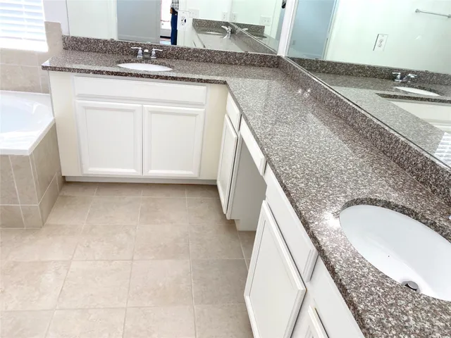 a en suite bathroom with a granite countertop sink and a vanity
