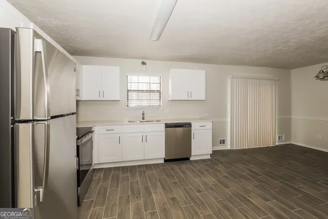 a kitchen with a refrigerator sink and cabinets