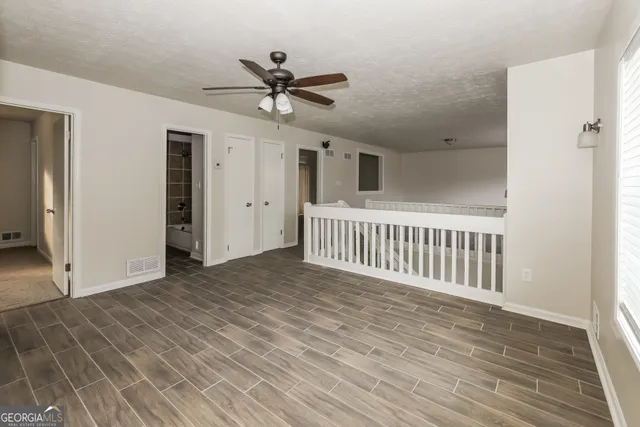 a view of a livingroom with a ceiling fan and wooden floor