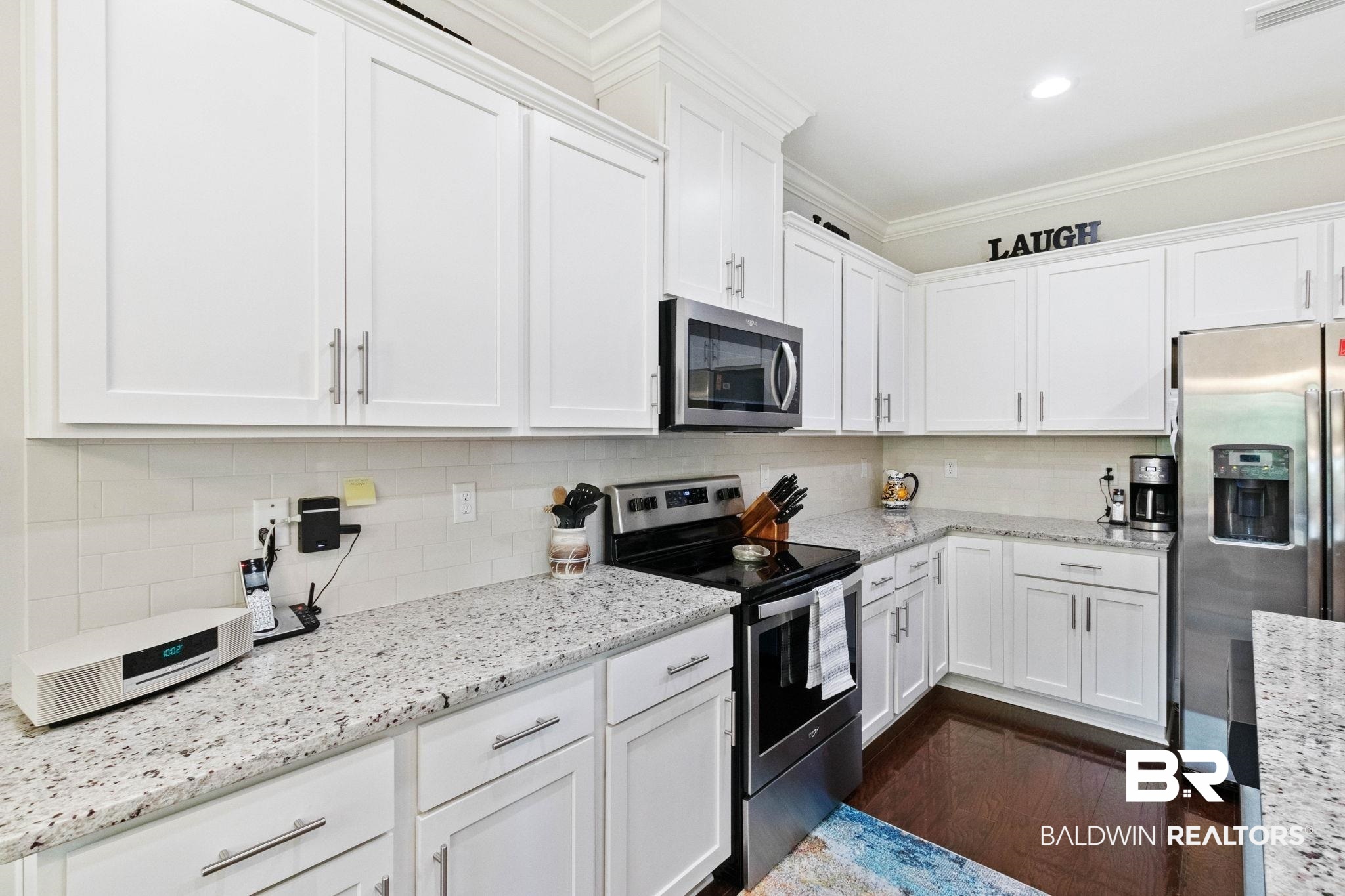 192 Mark Twain Loop Foley, AL 36535 - Photo 9 of 42 Kitchen featuring white cabinetry, dark hardwood / wood-style flooring, stainless steel appliances, and ornamental molding