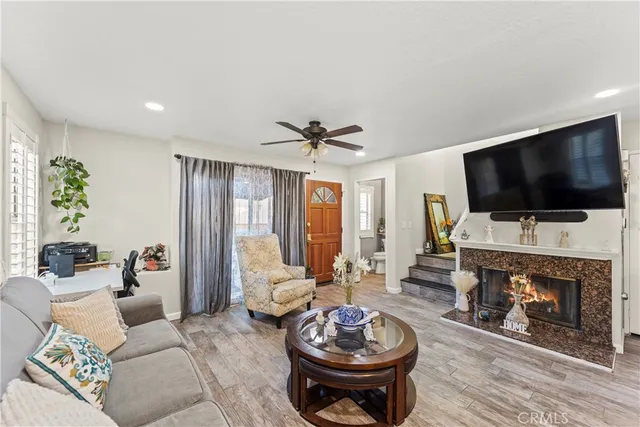 a living room with furniture a flat screen tv and a fireplace