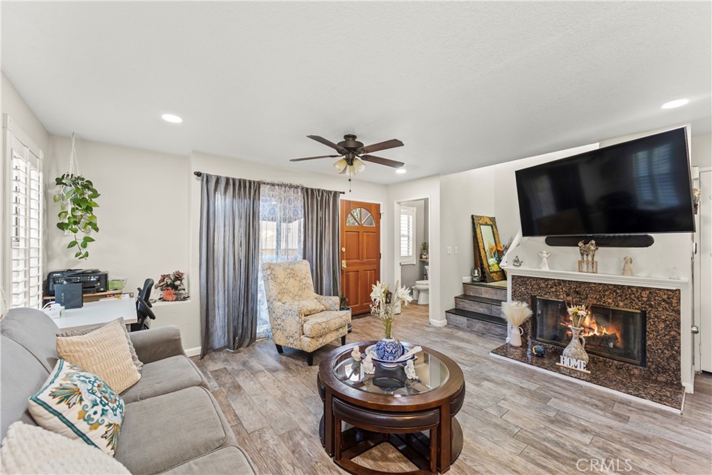 22617 Copper Hill Drive, Unit 121 Saugus, CA 91350 - Photo 1 of 24 a living room with furniture a flat screen tv and a fireplace