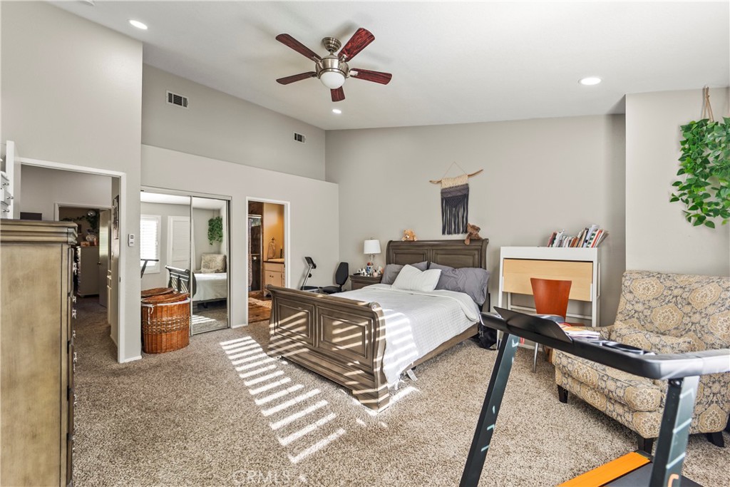 22617 Copper Hill Drive, Unit 121 Saugus, CA 91350 - Photo 12 of 24 a spacious bedroom with a bed a couch and a potted plant