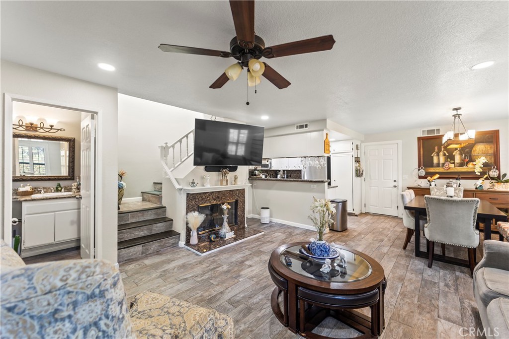 22617 Copper Hill Drive, Unit 121 Saugus, CA 91350 - Photo 2 of 24 a living room with furniture a fireplace and a flat screen tv