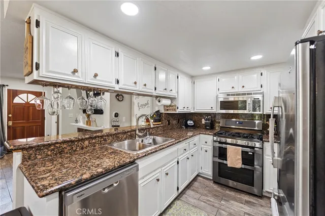 a kitchen with stainless steel appliances granite countertop a sink stove and refrigerator