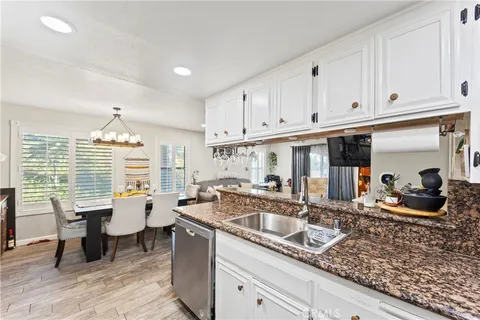 a kitchen with granite countertop a sink dining table and chairs
