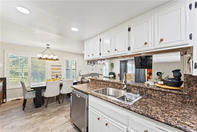 a kitchen with granite countertop a sink dining table and chairs