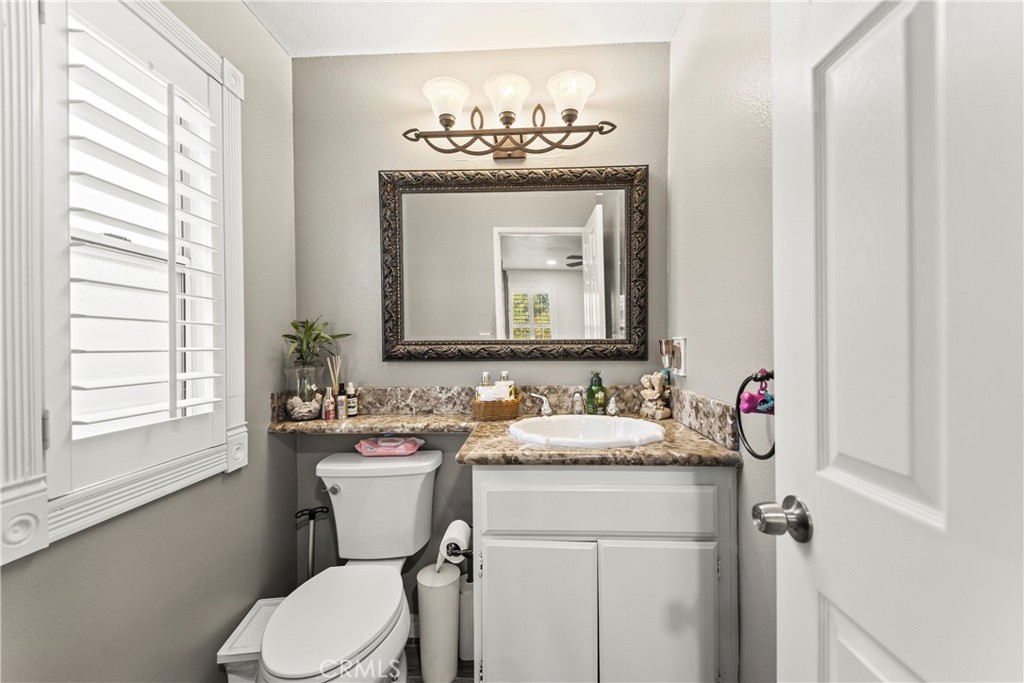 22617 Copper Hill Drive, Unit 121 Saugus, CA 91350 - Photo 10 of 24 a bathroom with a toilet sink and mirror