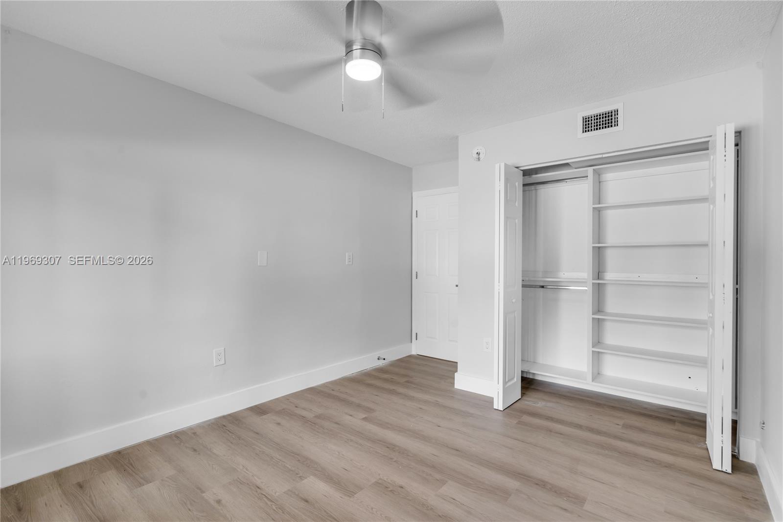 560 Northeast 63rd Street, Unit 3 Miami, FL 33138 - Photo 21 of 23 a view of an empty room with wooden floor closet and windows