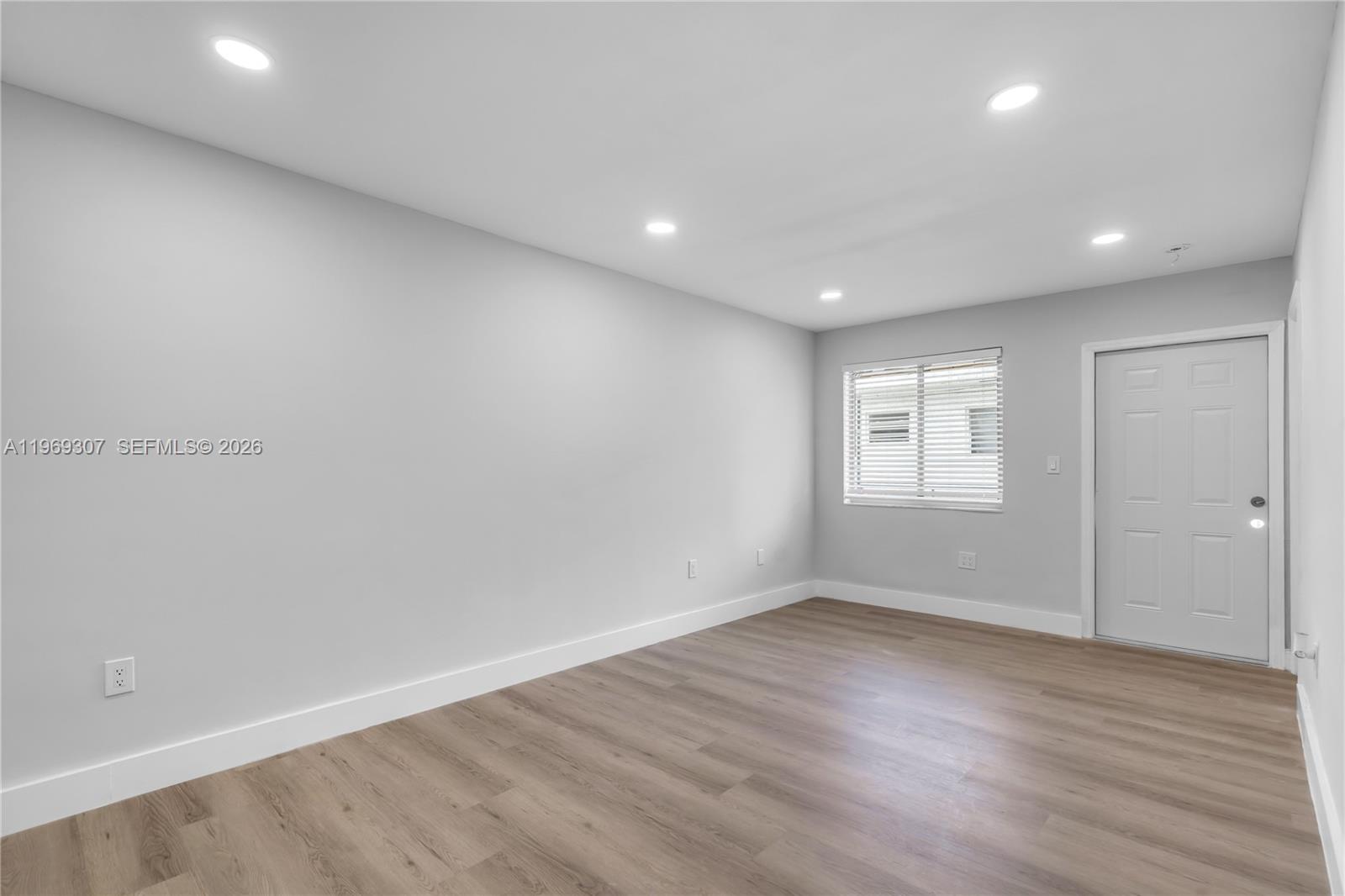 560 Northeast 63rd Street, Unit 3 Miami, FL 33138 - Photo 5 of 23 an empty room with wooden floor and windows