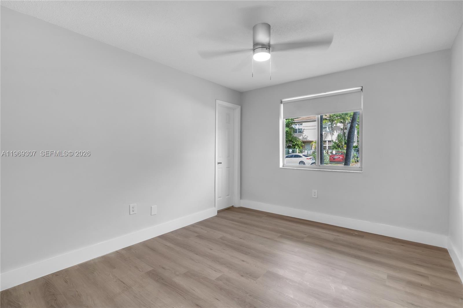 560 Northeast 63rd Street, Unit 3 Miami, FL 33138 - Photo 7 of 23 wooden floor in an empty room with a window