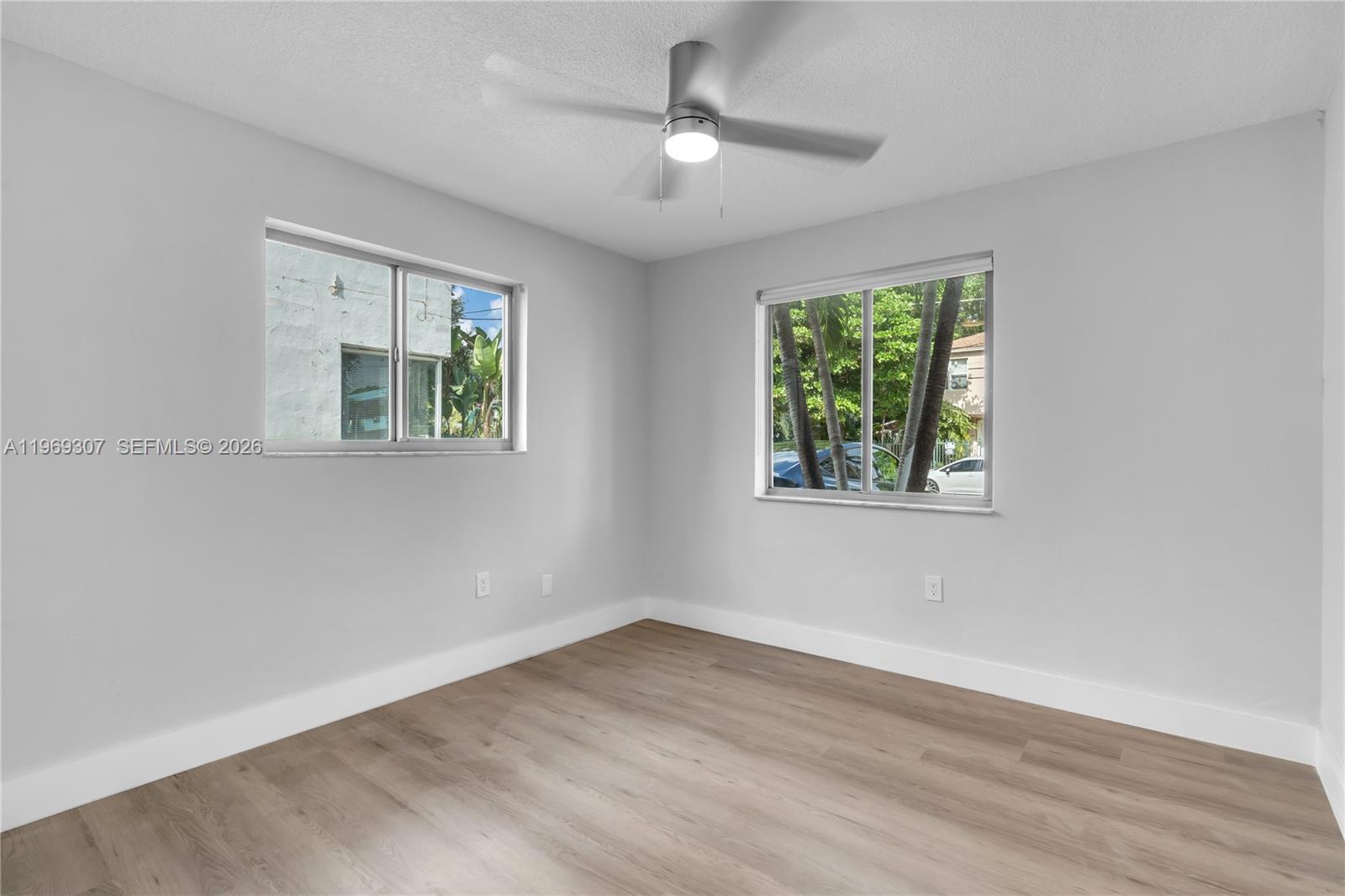560 Northeast 63rd Street, Unit 3 Miami, FL 33138 - Photo 8 of 23 wooden floor in an empty room with a window
