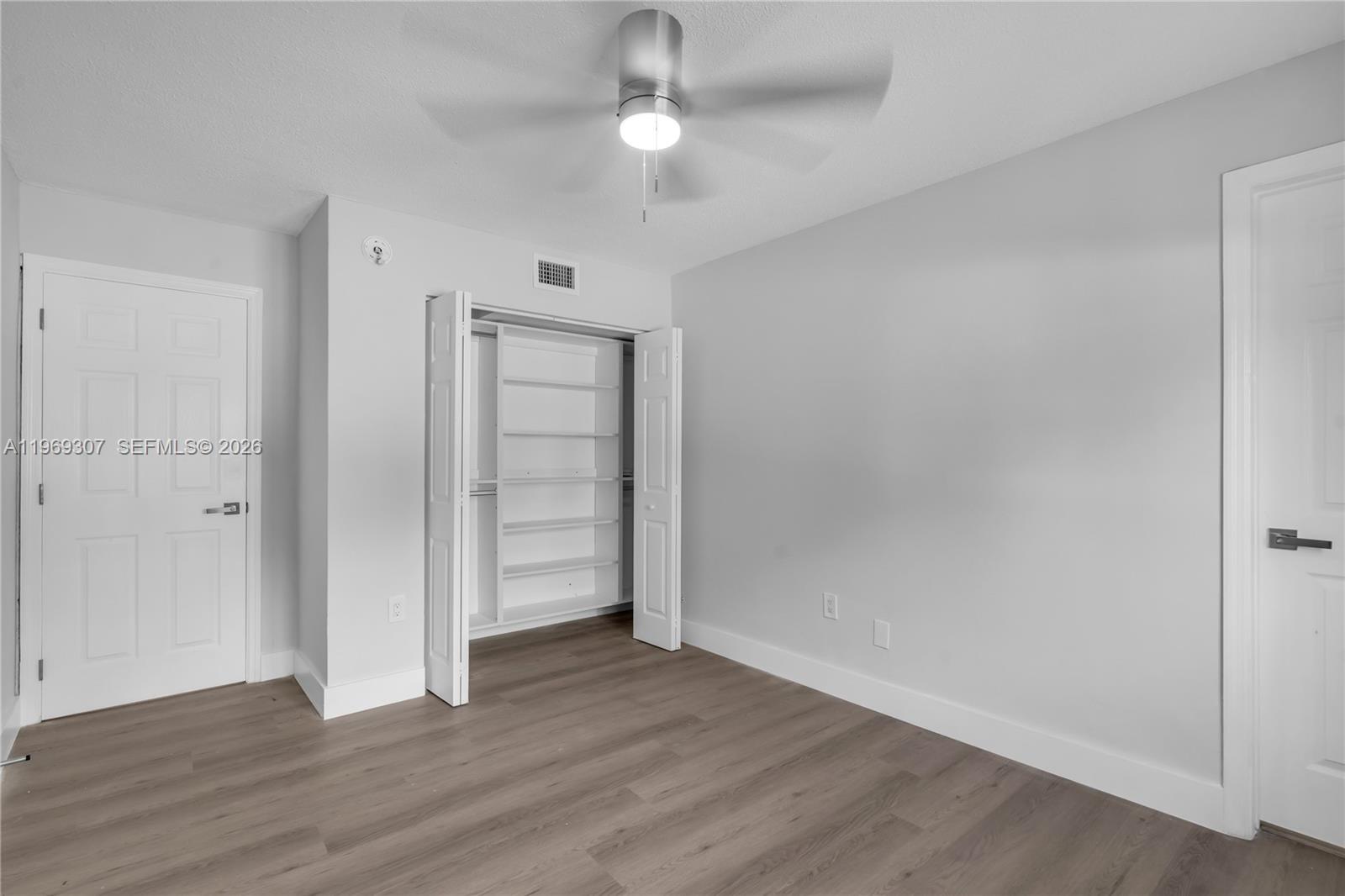 560 Northeast 63rd Street, Unit 3 Miami, FL 33138 - Photo 10 of 23 an empty room with wooden floor closet and windows