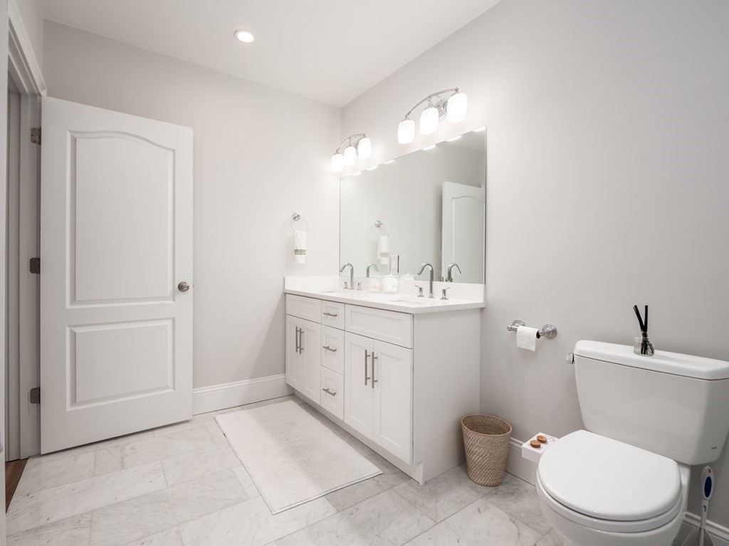45 L Street, Unit 21 Boston, MA 02127 - Photo 21 of 23 a bathroom with a toilet sink and mirror