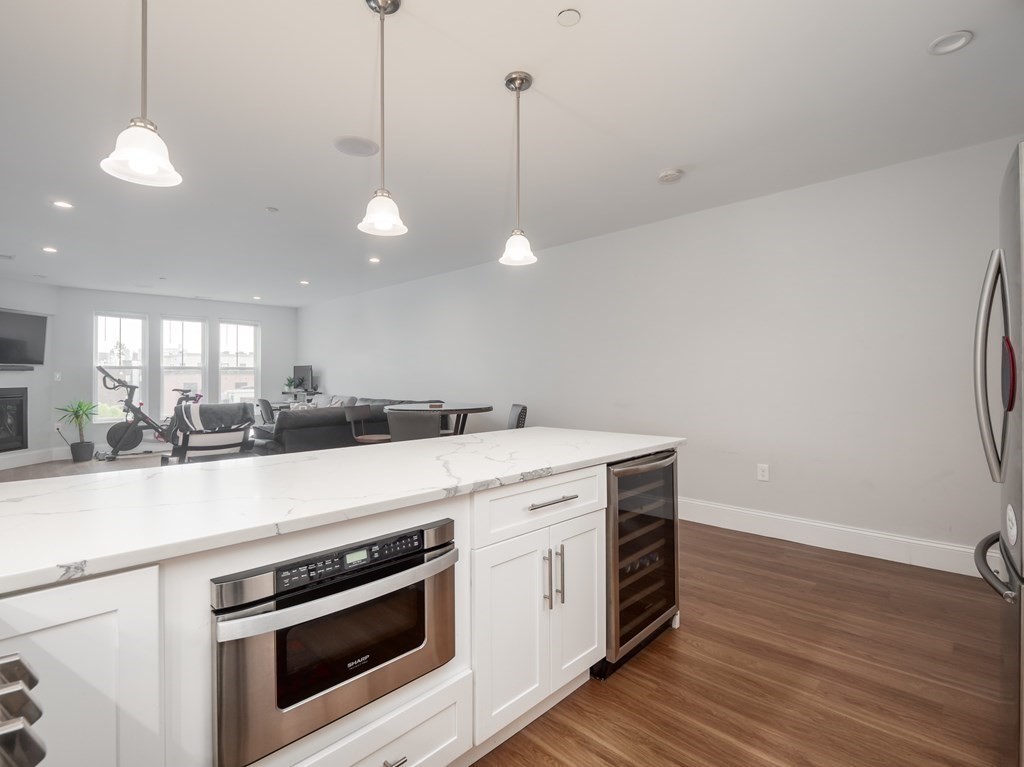 45 L Street, Unit 21 Boston, MA 02127 - Photo 5 of 23 a kitchen with a stove and a wooden floor