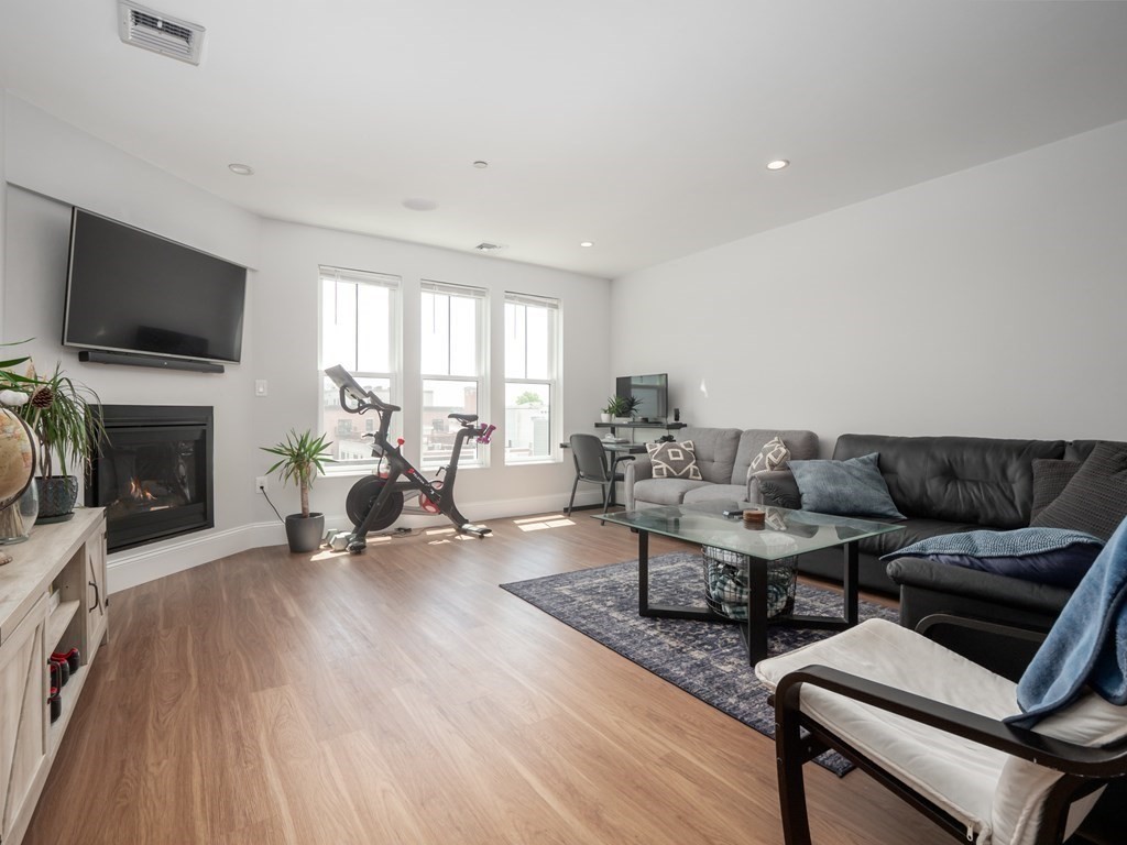 45 L Street, Unit 21 Boston, MA 02127 - Photo 10 of 23 a living room with furniture a flat screen tv and a fireplace