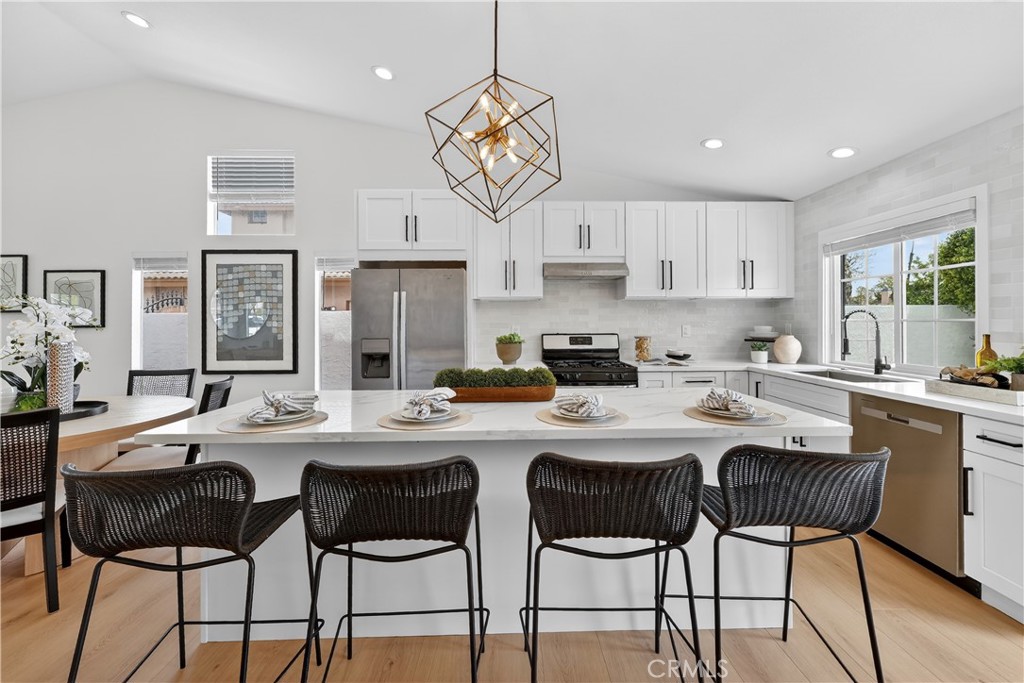 1263 Cornerstone Way Corona, CA 92878 - Photo 6 of 20 a kitchen with stainless steel appliances granite countertop a stove a sink a refrigerator a dining table and chairs