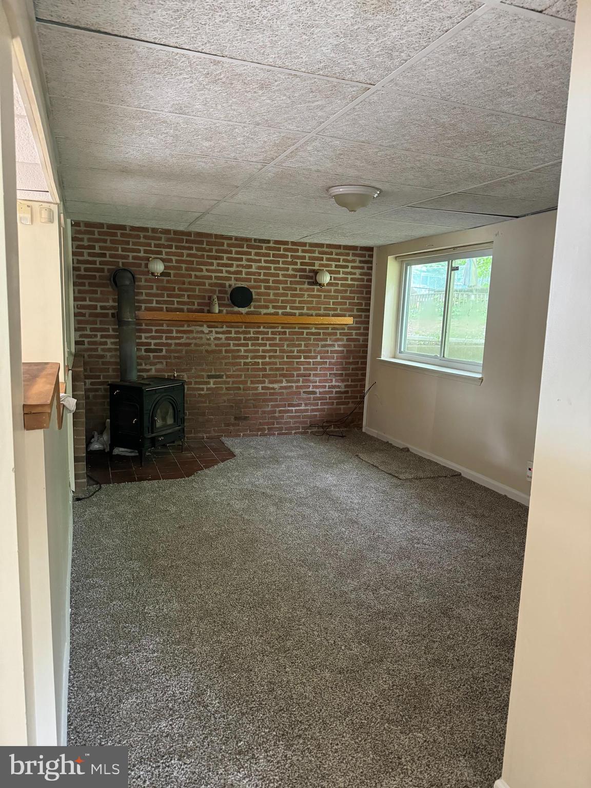 9401 Cheltenham Avenue Clinton, MD 20735 - Photo 8 of 16 an empty room with a fireplace and a window