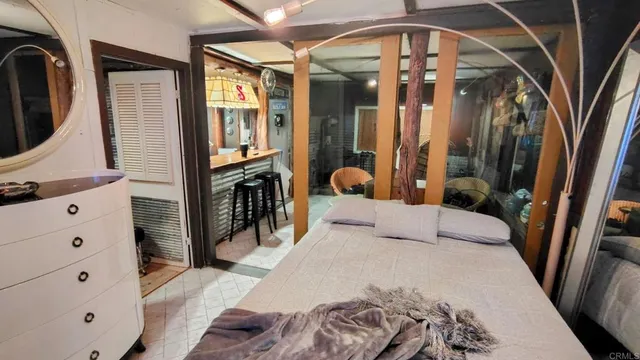 a bedroom with a large bed a flat tv screen and dresser