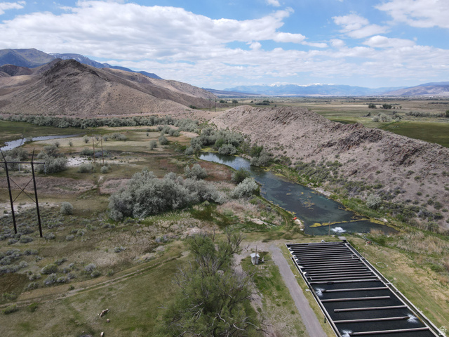 202 North Westhaven Road Richfield, UT 84701 - Photo 5 of 10 Expansive rural landscape featuring a river, mountainous terrain, and a large aquaculture facility