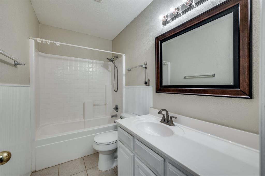 6812 Cold Water Canyon Road Fort Worth, TX 76132 - Photo 12 of 12 a bathroom with a toilet a sink a mirror and a bathtub