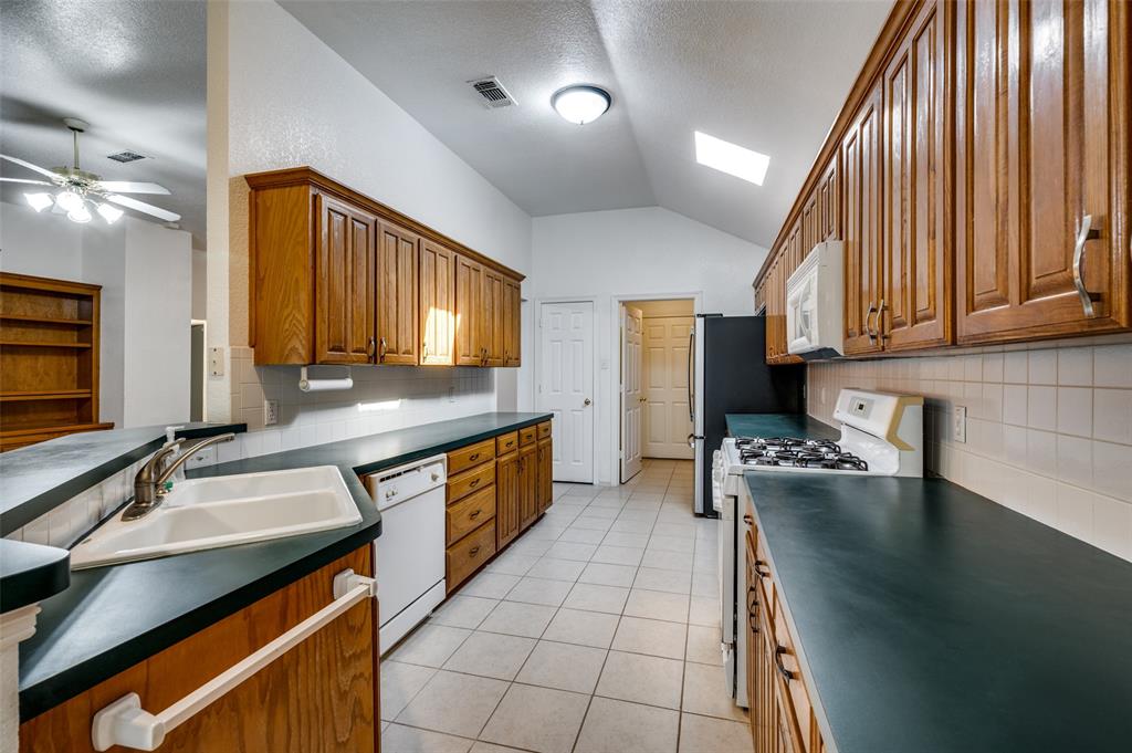 6812 Cold Water Canyon Road Fort Worth, TX 76132 - Photo 6 of 12 a kitchen with stainless steel appliances granite countertop a sink a stove counter space and cabinets