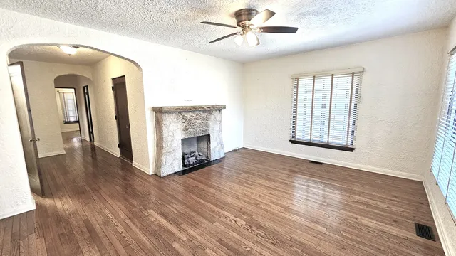 a view of an empty room with a window and fireplace