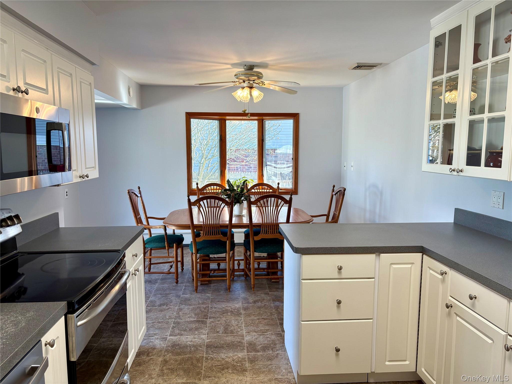 223 Timber Point Road East Islip, NY 11730 - Photo 11 of 47 a kitchen with a stove a table and chairs