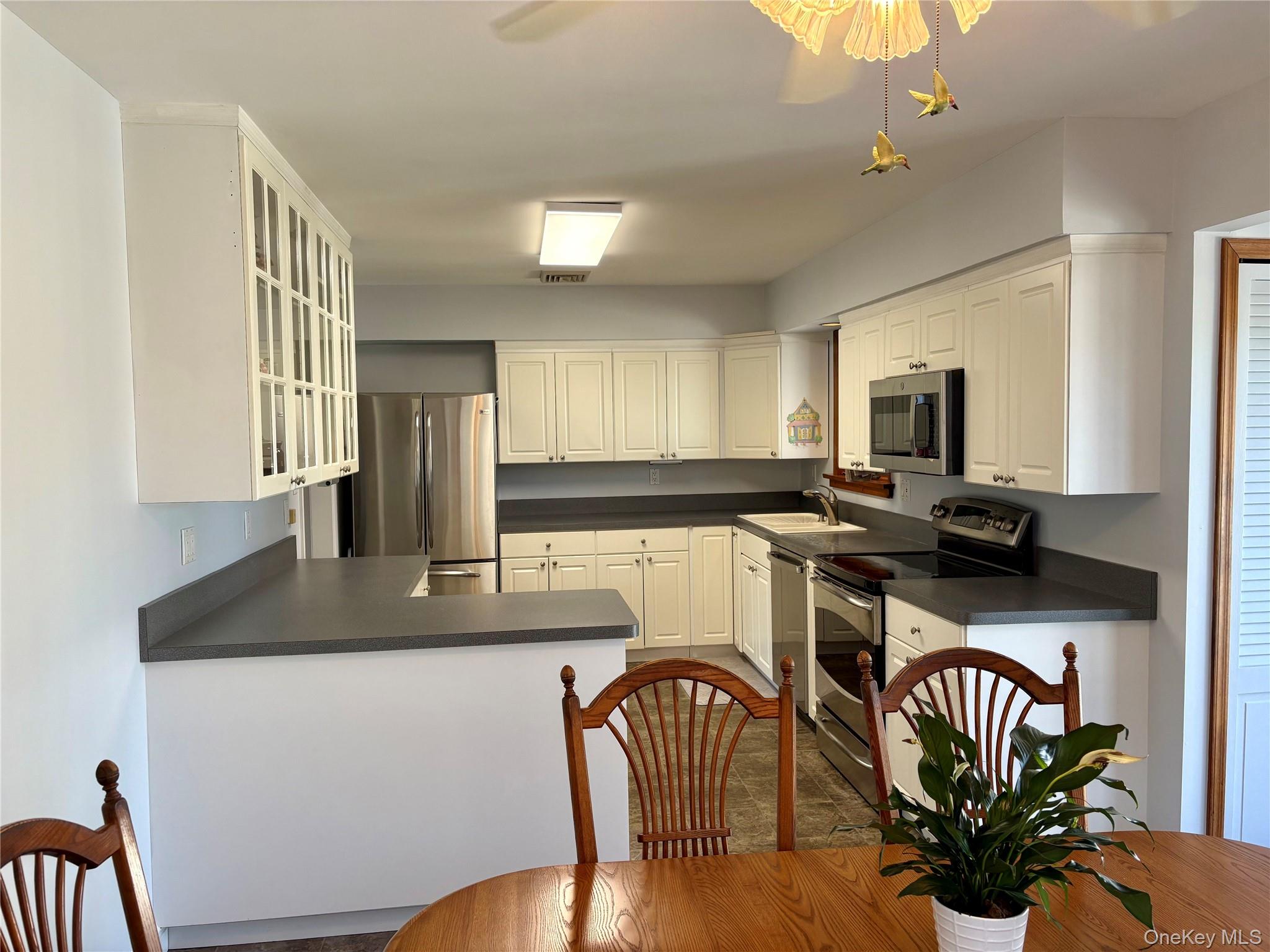 223 Timber Point Road East Islip, NY 11730 - Photo 14 of 47 a kitchen with a table chairs and a refrigerator
