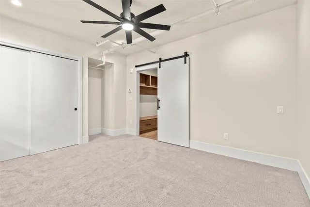 an empty room with closet and a ceiling fan