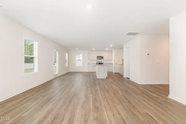 a view of a kitchen with wooden floor and a window