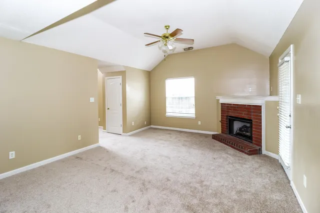 a view of a livingroom with a fireplace and chandelier fan