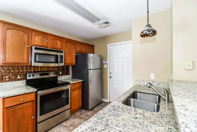 a kitchen with stainless steel appliances granite countertop a sink stove and refrigerator