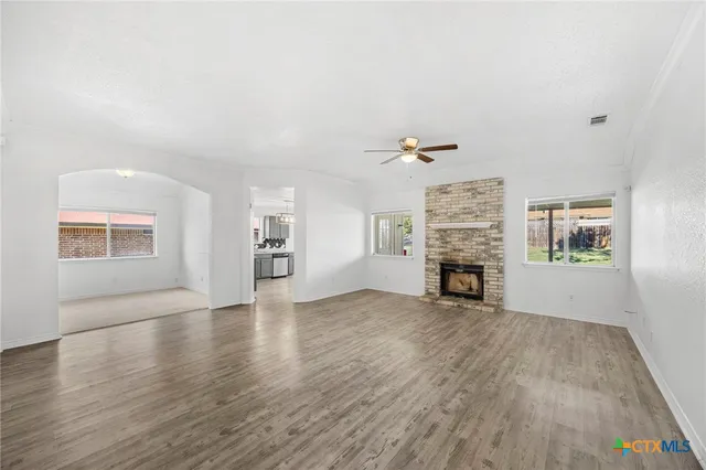 an empty room with windows and fireplace