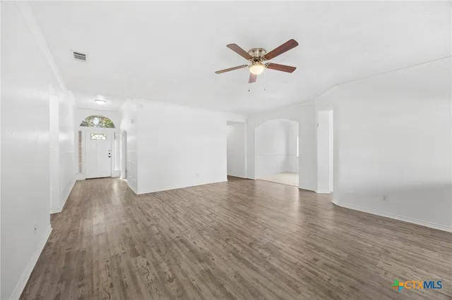 a view of empty room with wooden floor