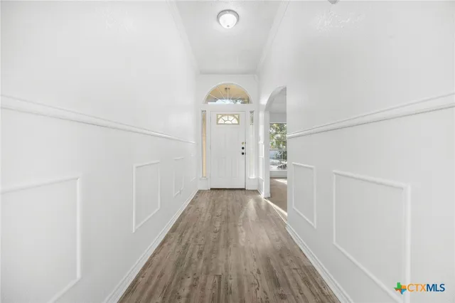 a view of a hallway with wooden floor