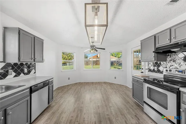 a kitchen with stainless steel appliances a stove a sink and a refrigerator
