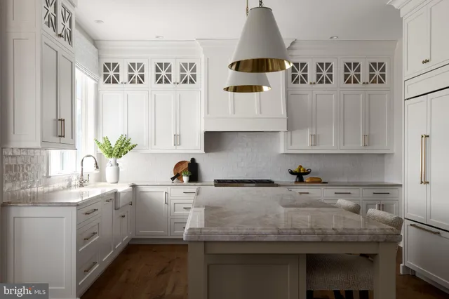a kitchen with stainless steel appliances a sink a refrigerator and cabinets