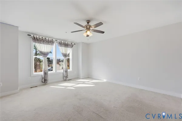 a view of a livingroom with a ceiling fan and window